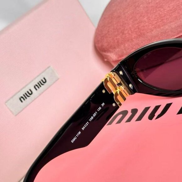 Miu Miu black sunglasses featuring elegant gold accents